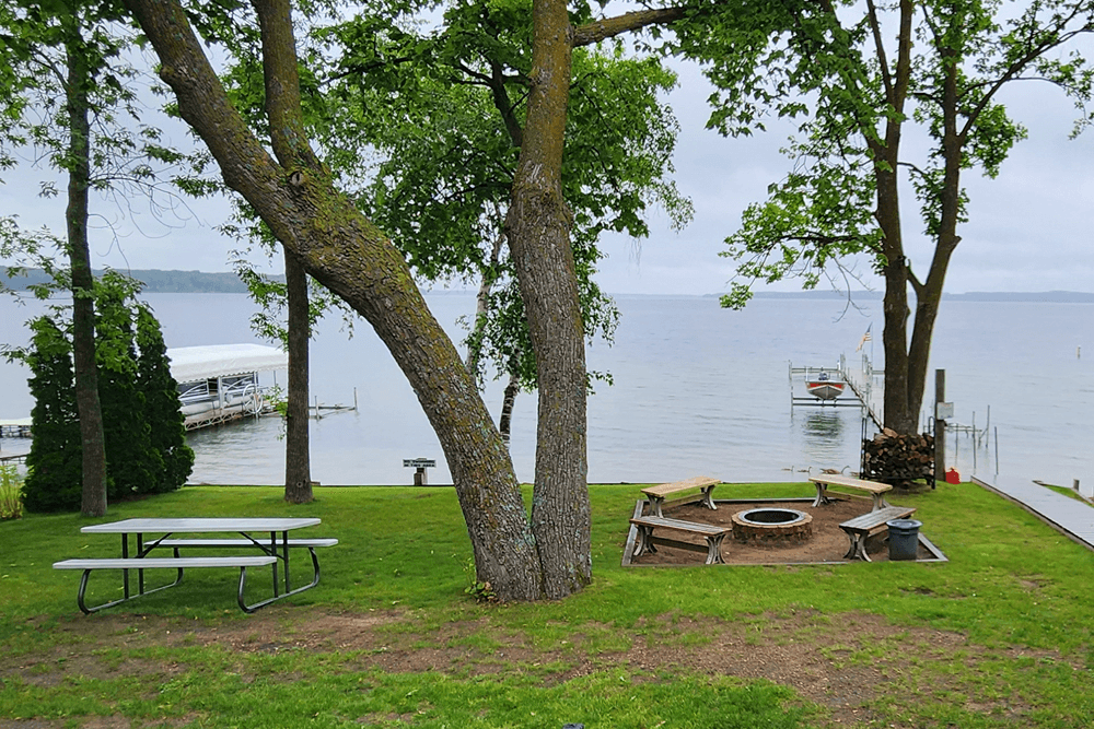 View of lake with firepit and doc and picnic table